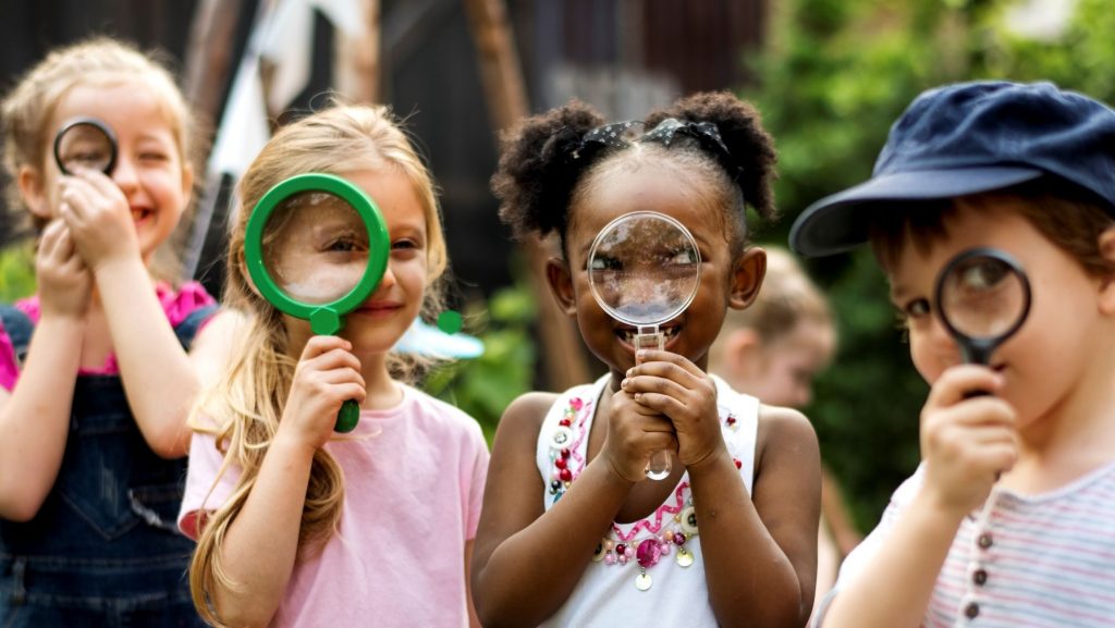 Kids exploring nature with hand lenses