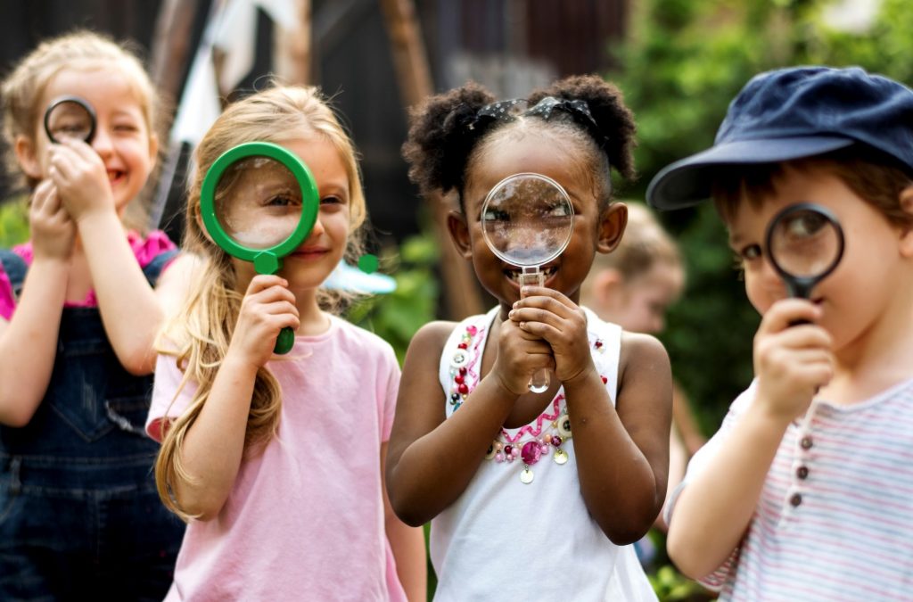 Kids exploring nature with hand lenses