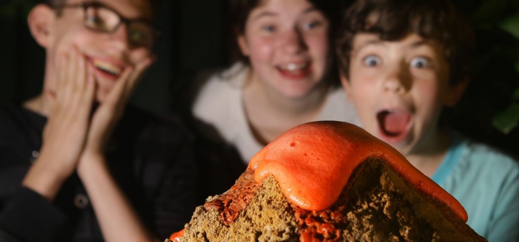 Kids watching model volcano explode