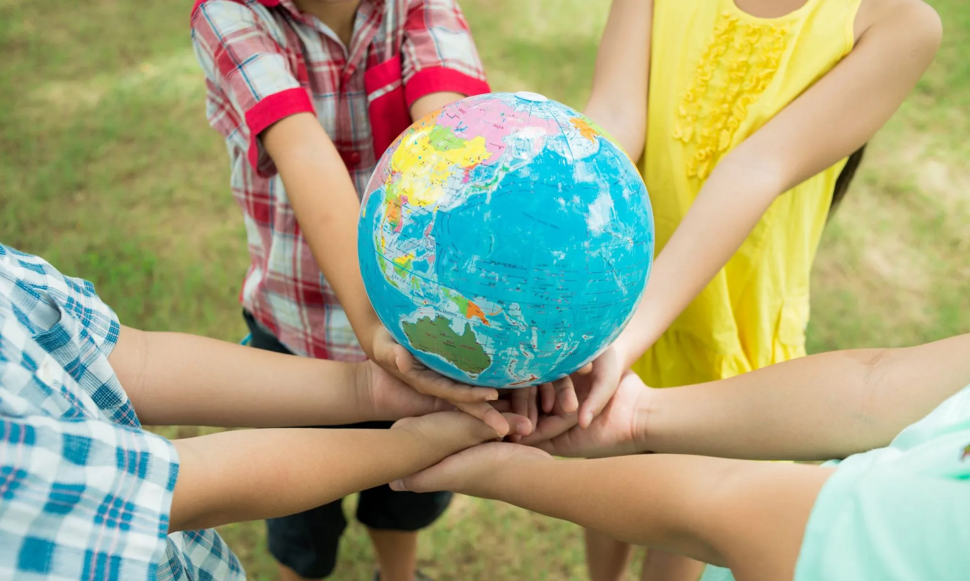 the world is in their hands; kids holding globe
